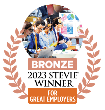 Eine Grafik, die eine bronzene Auszeichnung für 'Beste Arbeitgeber' zeigt, mit einer Illustration von vier Fachleuten, die an einem Besprechungstisch zusammenarbeiten, umgeben von Tabellen und Diagrammen.